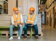 Two warehouse workers discuss health and safety practices