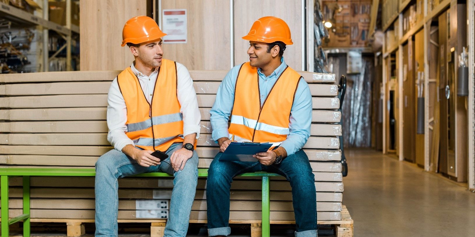 Workplace-health-safety Two warehouse workers discuss health and safety practices