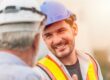 Worker in safety gear talks to his supervisor